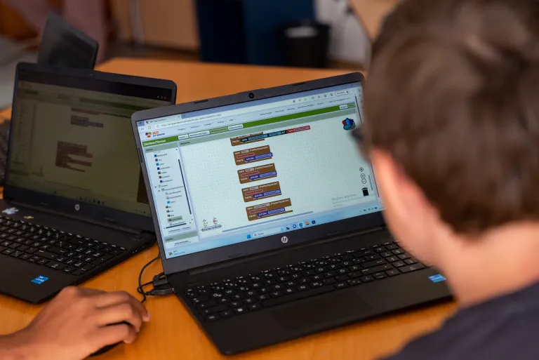 Kind programmiert mit App Inventor am Laptop