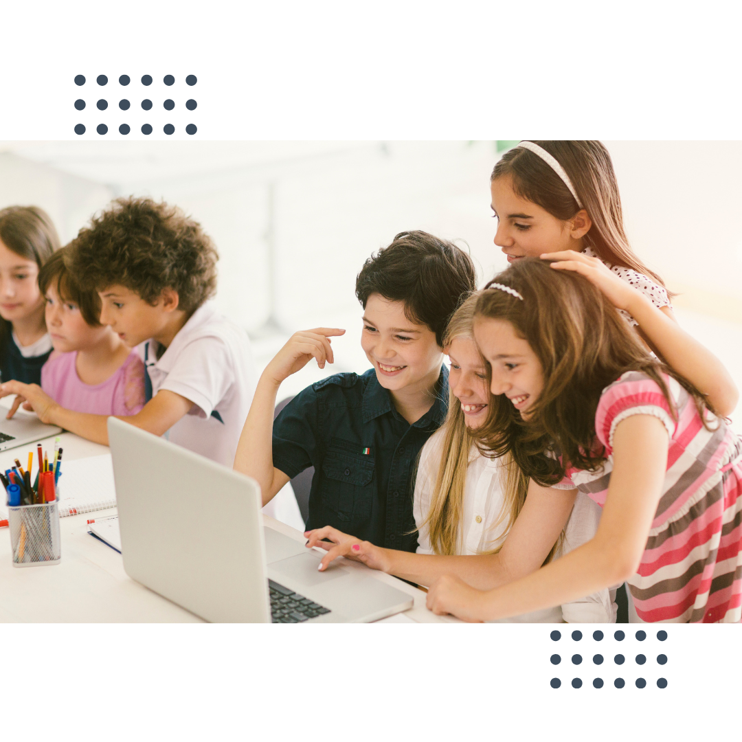 Gruppe von Kindern, die gemeinsam an einem Laptop arbeiten, lächelnd und kreativ tätig.