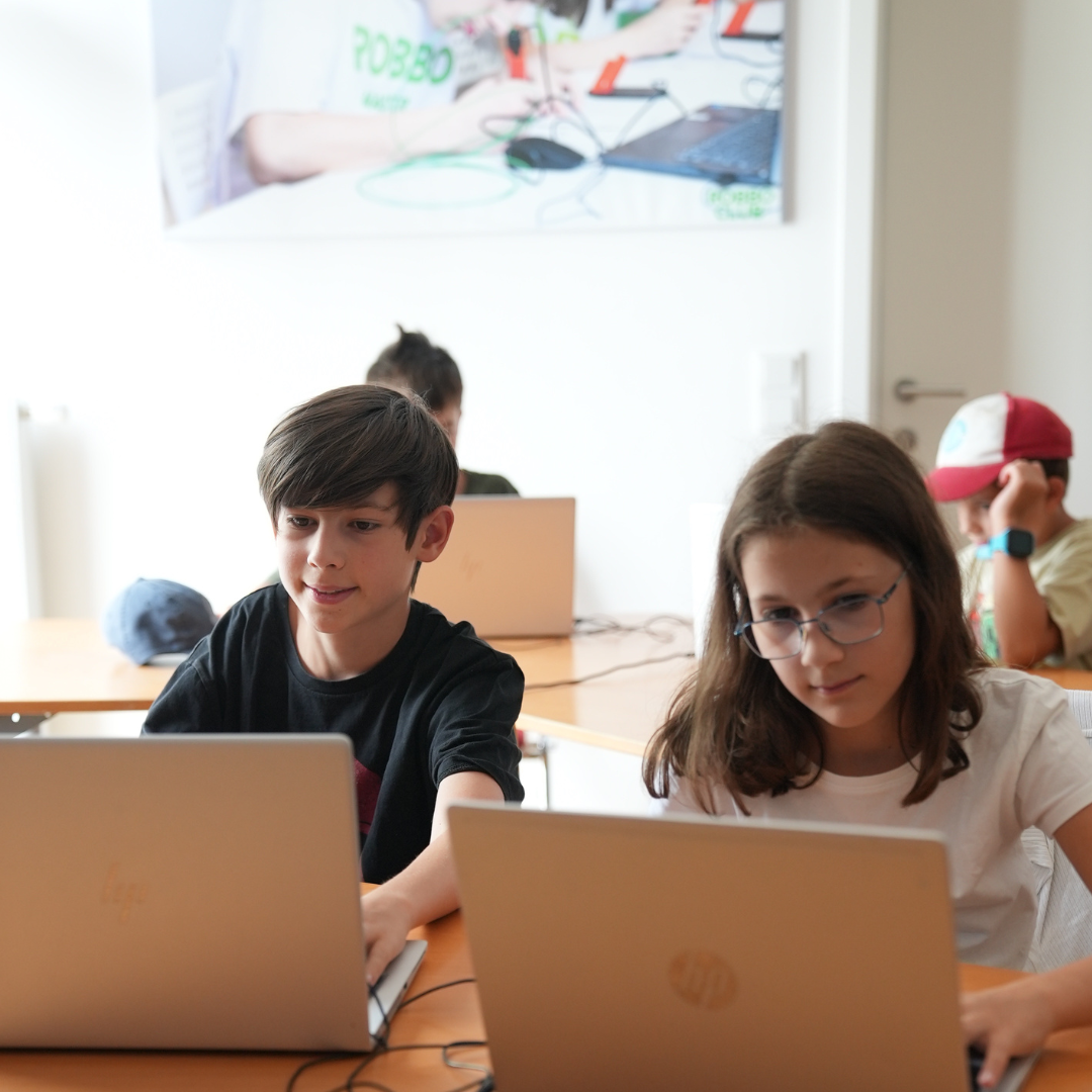 Kinder arbeiten gemeinsam am Computer im Robbo-Camp.