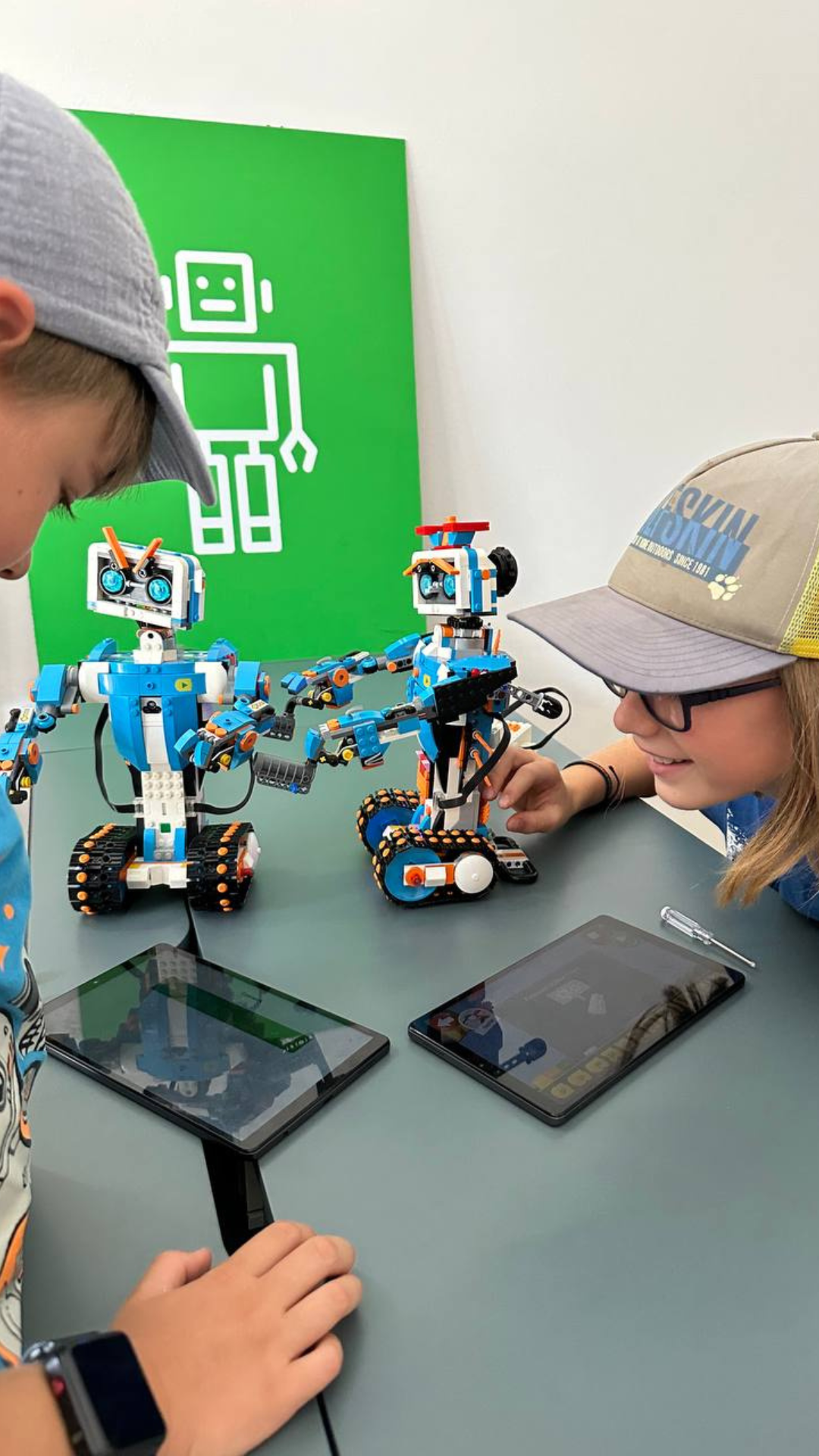 Kinder im Robbo Sommercamp programmieren und interagieren mit LEGO-Robotern."