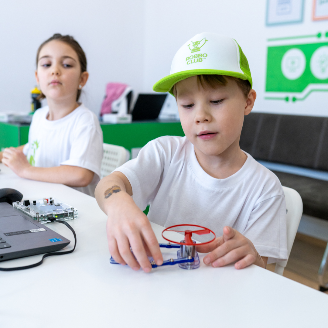 Kinder im Robbo Club Sommercamp bauen ein einfaches Modell mit Propeller.
