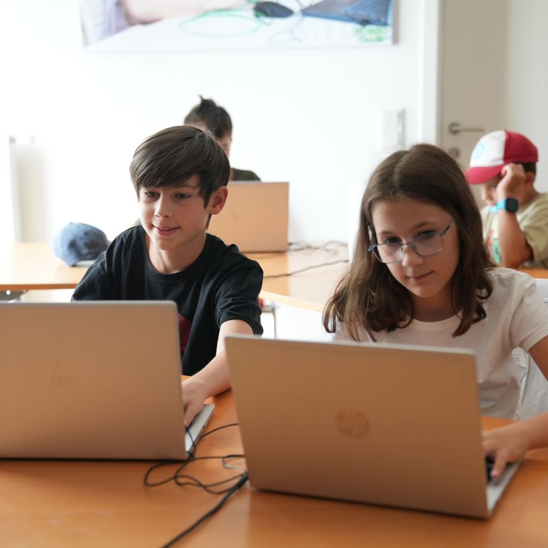 Kinder im Roblox-Sommercamp des Robbo Clubs gestalten und programmieren eigene Spiele auf dem Laptop.