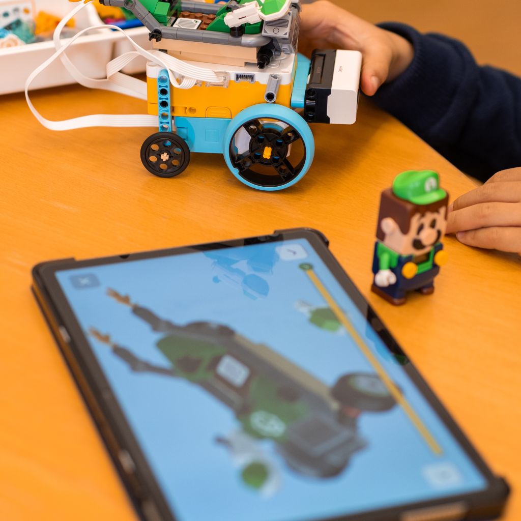 Kind programmiert ein Lego Super Mario Kart mit Tablet und SPIKE Roboter