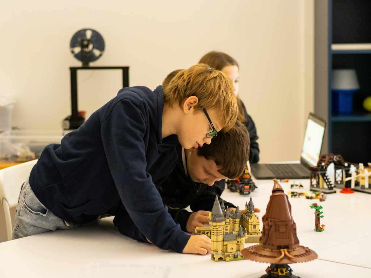 Kinder bauen im LEGO® Harry-Potter-Workshop des ROBBO Club Wien kreative Hogwarts-Modelle.