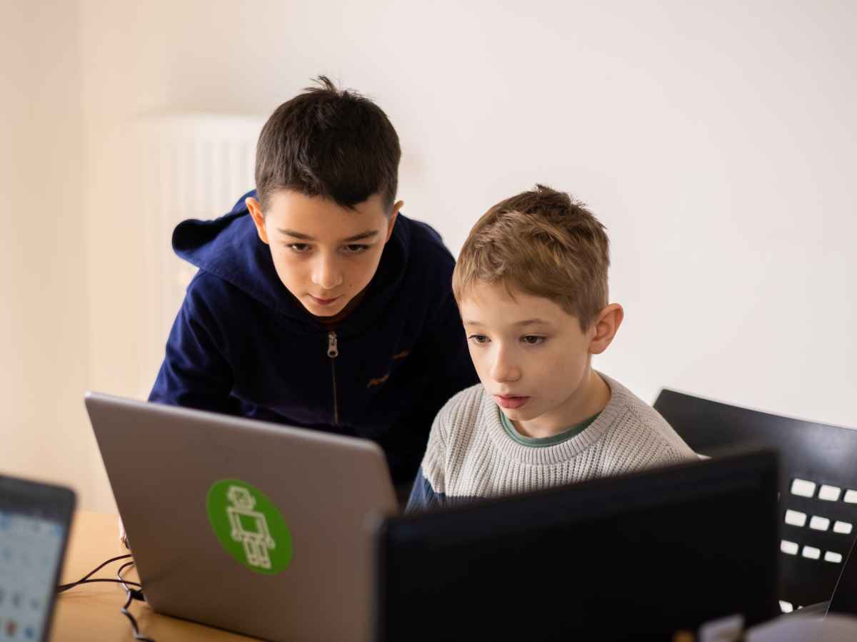 Zwei Kinder arbeiten gemeinsam am Laptop im Technikworkshop.