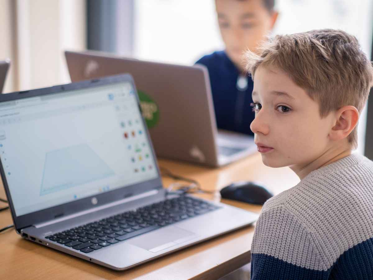 Kind sitzt am Laptop und arbeitet an einem 3D-Design im Kurs.