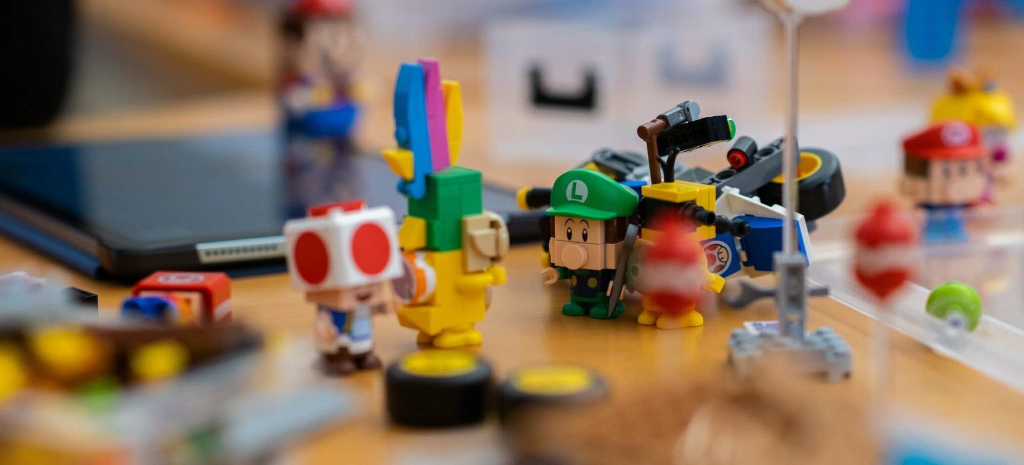 Super-Mario-LEGO-Figuren und Bauteile liegen auf einem Tisch im Robbo Club während eines Kindergeburtstags.