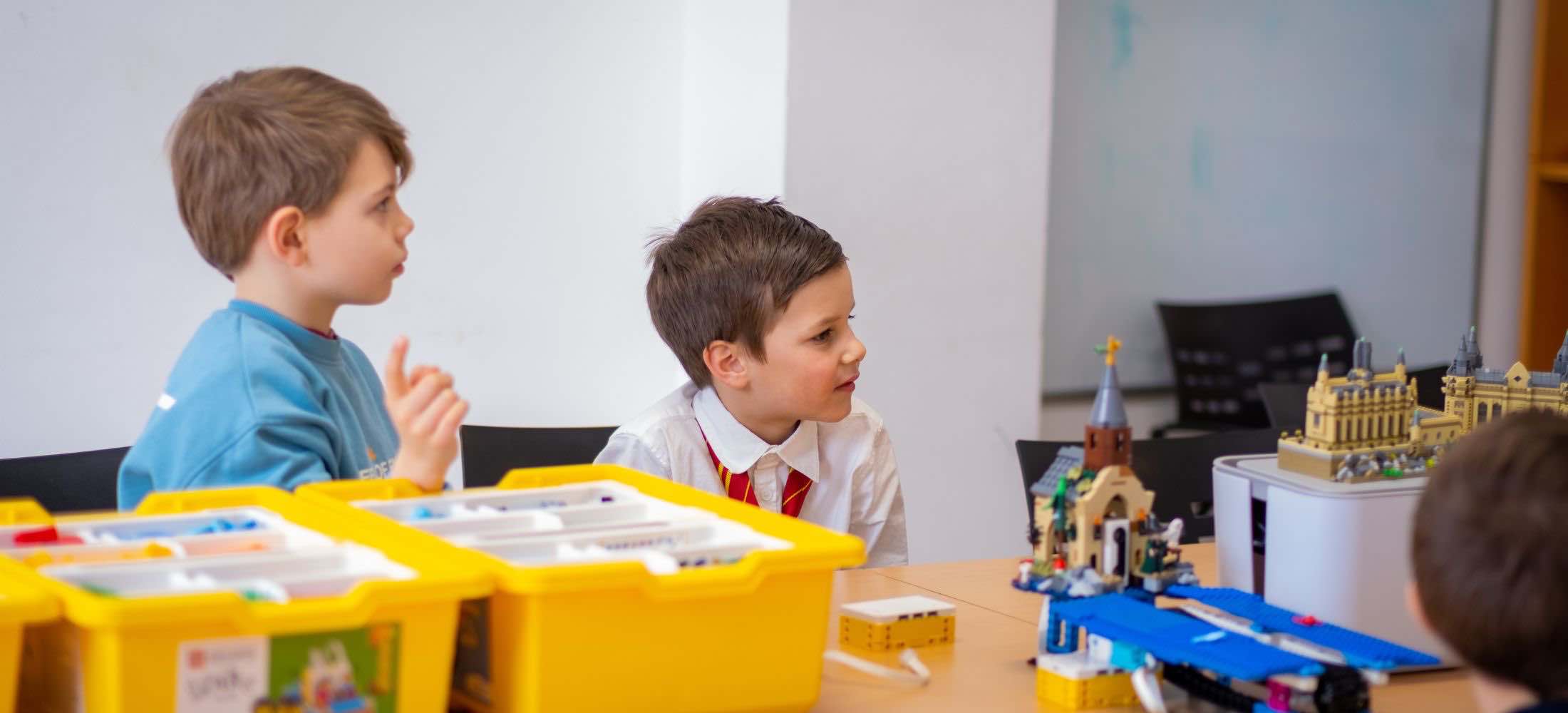 Kinder bauen LEGO-Modelle beim Robbo Club Kindergeburtstag und arbeiten konzentriert an ihren Projekten.