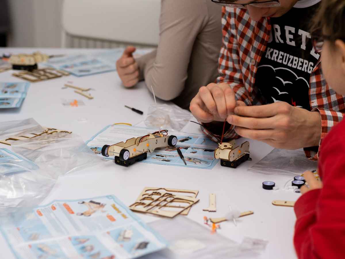 Kind arbeitet an einem Robotik-Modell mit Kleinteilen.