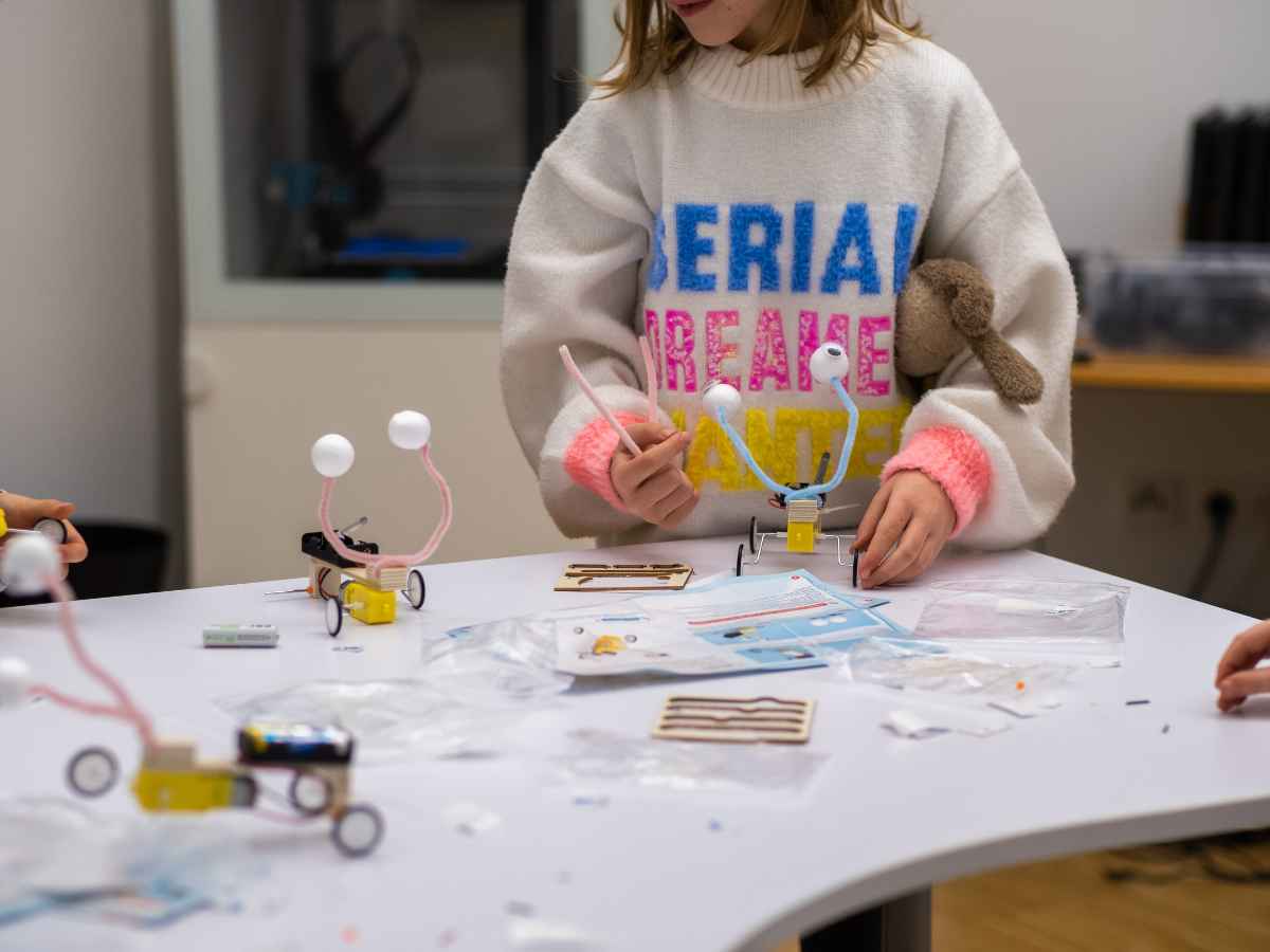 Kinder bauen kleine technische Fahrzeuge aus Bausätzen.
