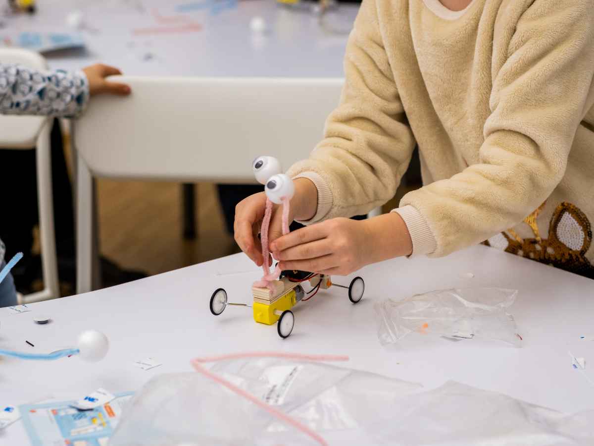 Kind entwickelt ein Fahrzeugmodell mit beweglichen Teilen.