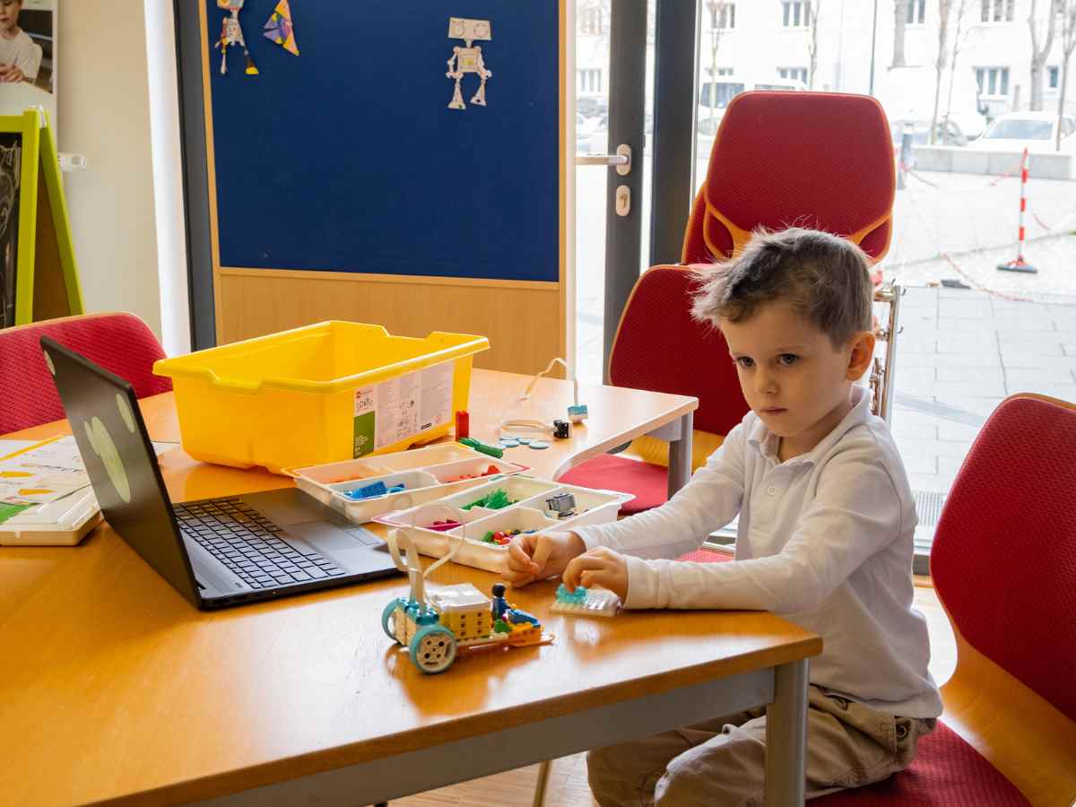 Jüngeres Kind baut ein LEGO Modell im ROBBO Club Workshop.