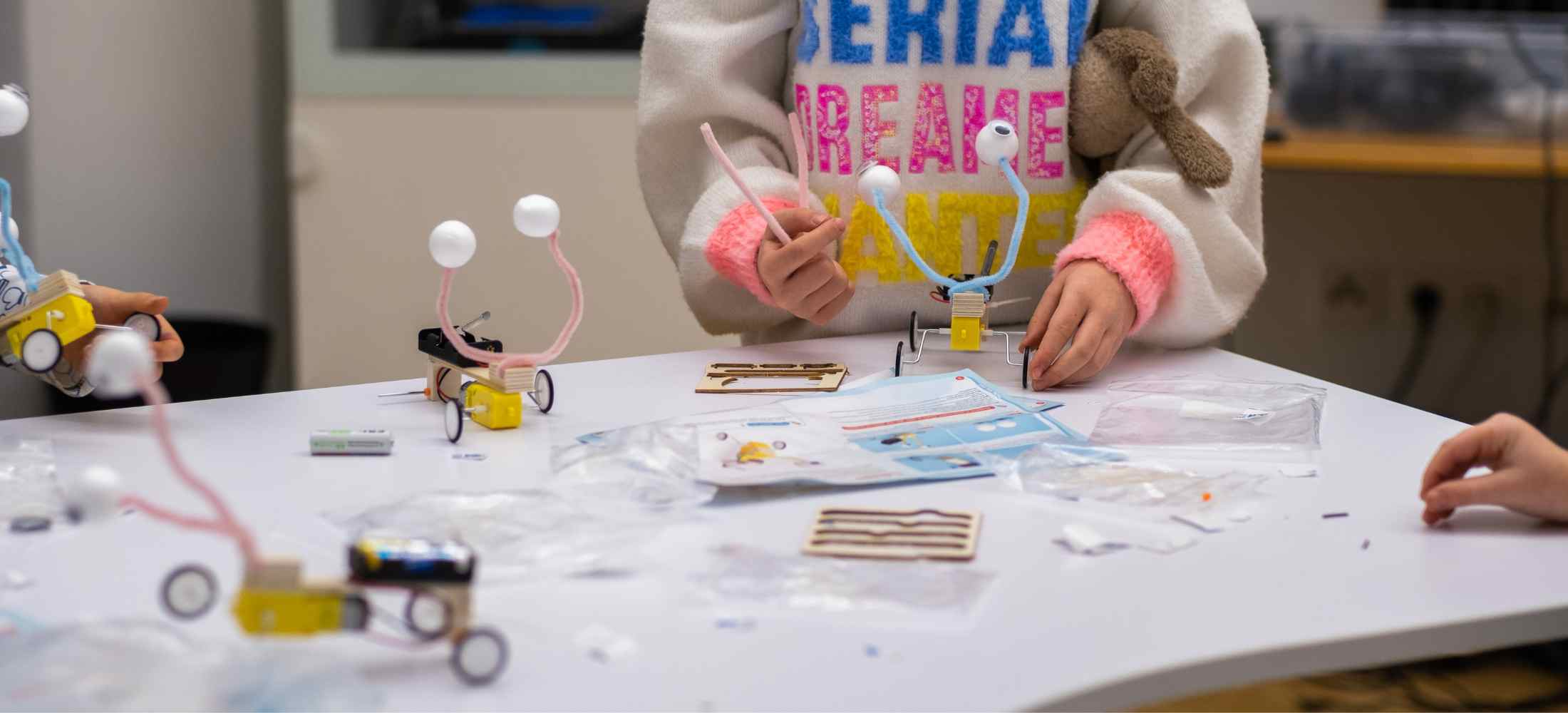 Kinder bauen kreative Technikfahrzeuge im Workshop.