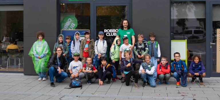 Kinder und Betreuer des Robbo Club Herbstcamps stehen gemeinsam vor dem Clubgebäude für ein Gruppenfoto.