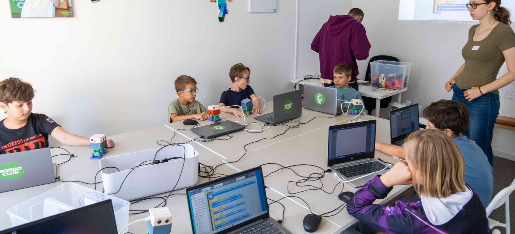 Kinder sitzen im Robbo Club im 2. Bezirk vor Laptops und programmieren gemeinsam während einer Geburtstagsparty.