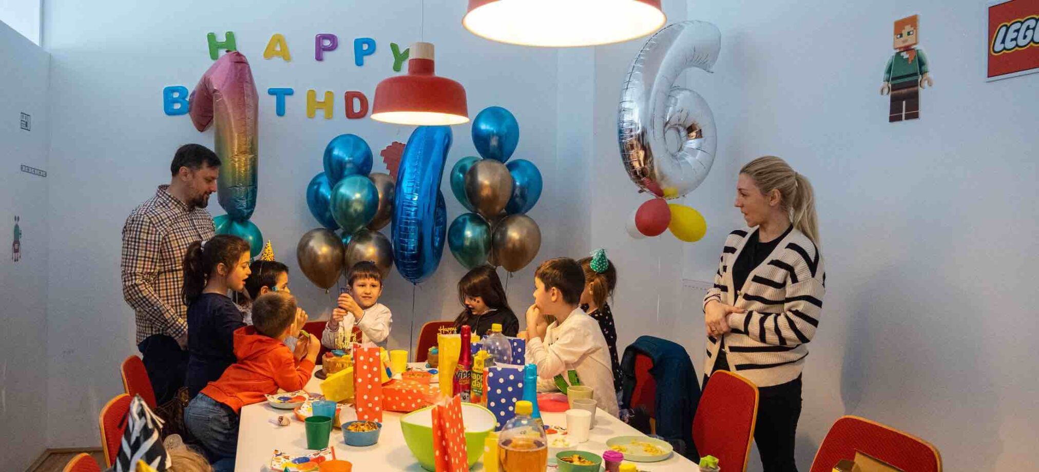 Kinder feiern einen farbenfrohen Geburtstag im Robbo Club im 9. Bezirk, mit Ballons, Geschenktüten und dekoriertem Geburtstagstisch.