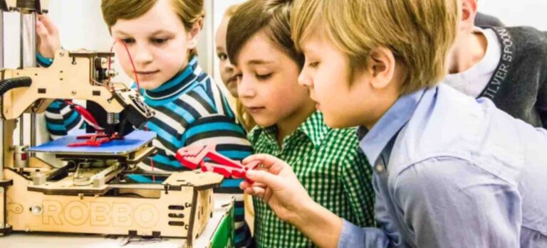 Kinder beobachten einen 3D-Drucker im Robbo Club während des Druckvorgangs.