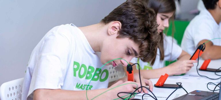 Jugendliche arbeiten im Robbo Club konzentriert mit 3D-Stiften und erstellen eigene dreidimensionale Modelle.