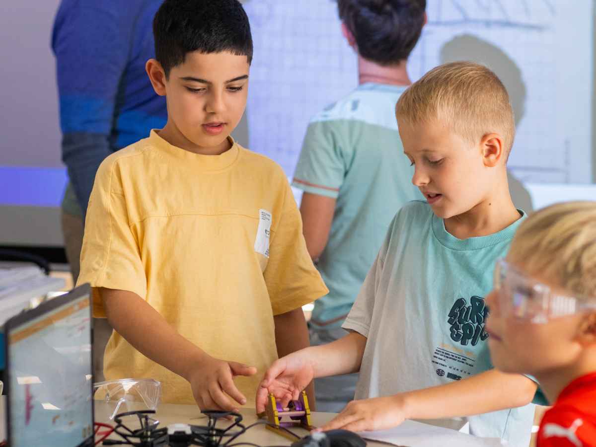 Kinder arbeiten gemeinsam an einem technischen Drohnenmodul