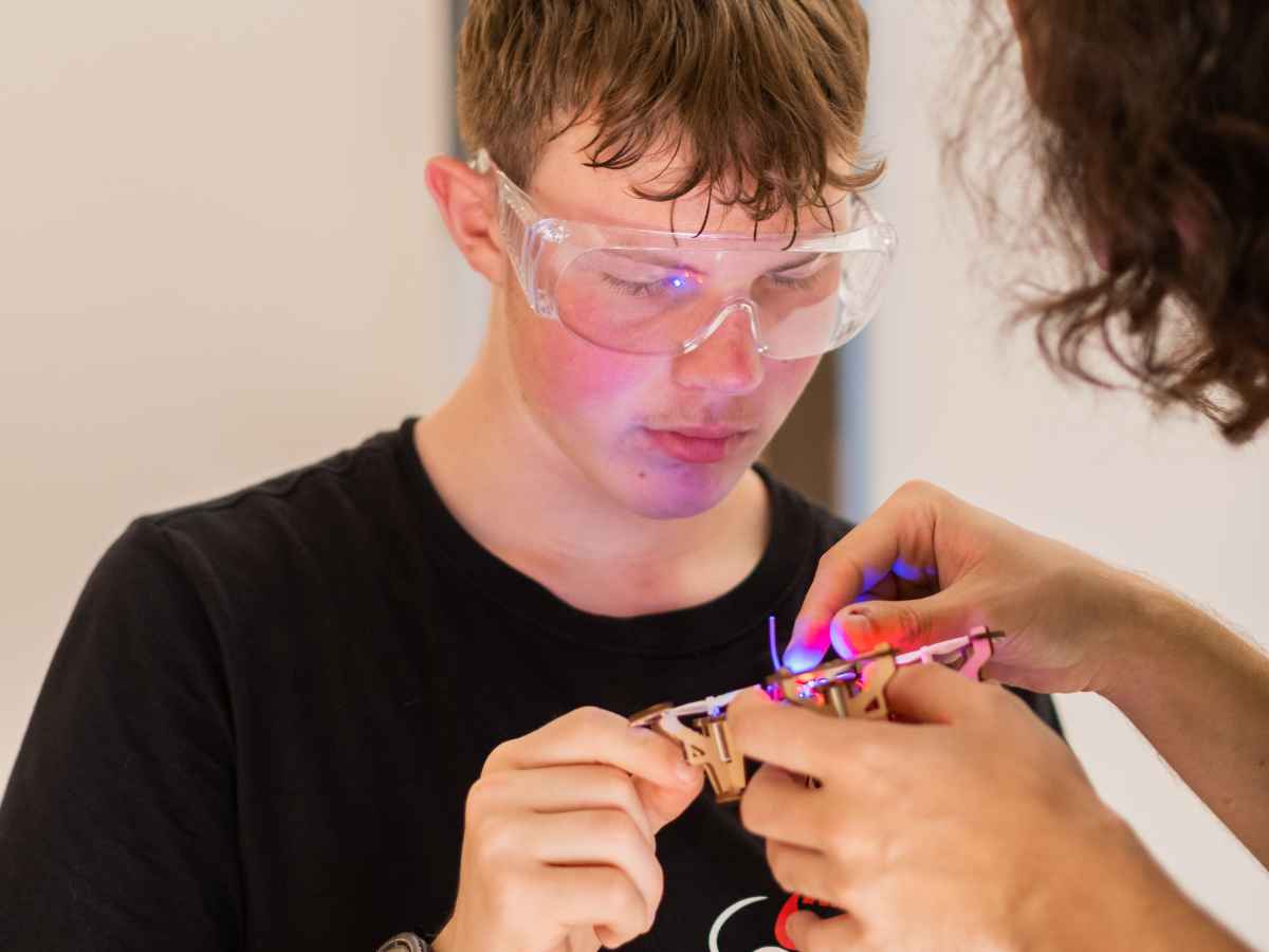 Jugendlicher montiert technische Komponenten eines Flugmoduls