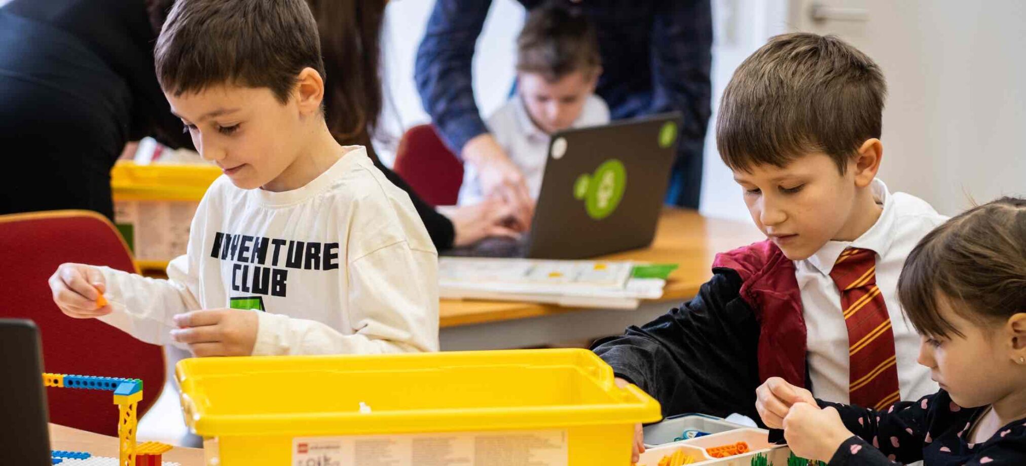 Kinder bauen mit LEGO und Technikbauteilen während eines Geburtstags-Workshops im Robbo Club und arbeiten gemeinsam an kreativen Projekten.