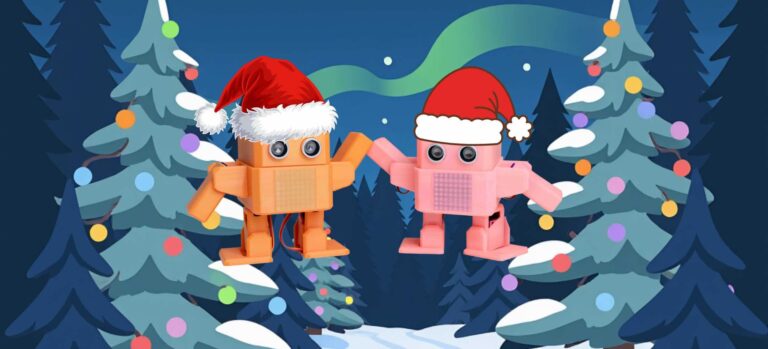Zwei kleine Roboter mit Weihnachtsmützen stehen vor weihnachtlich geschmückten Tannenbäumen in einer Winterlandschaft.
