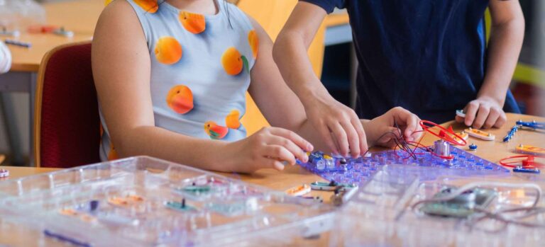Kinder arbeiten im Robbo Club an einem Technik-Experimentierset und bauen elektronische Projekte während eines Oster-Workshops.