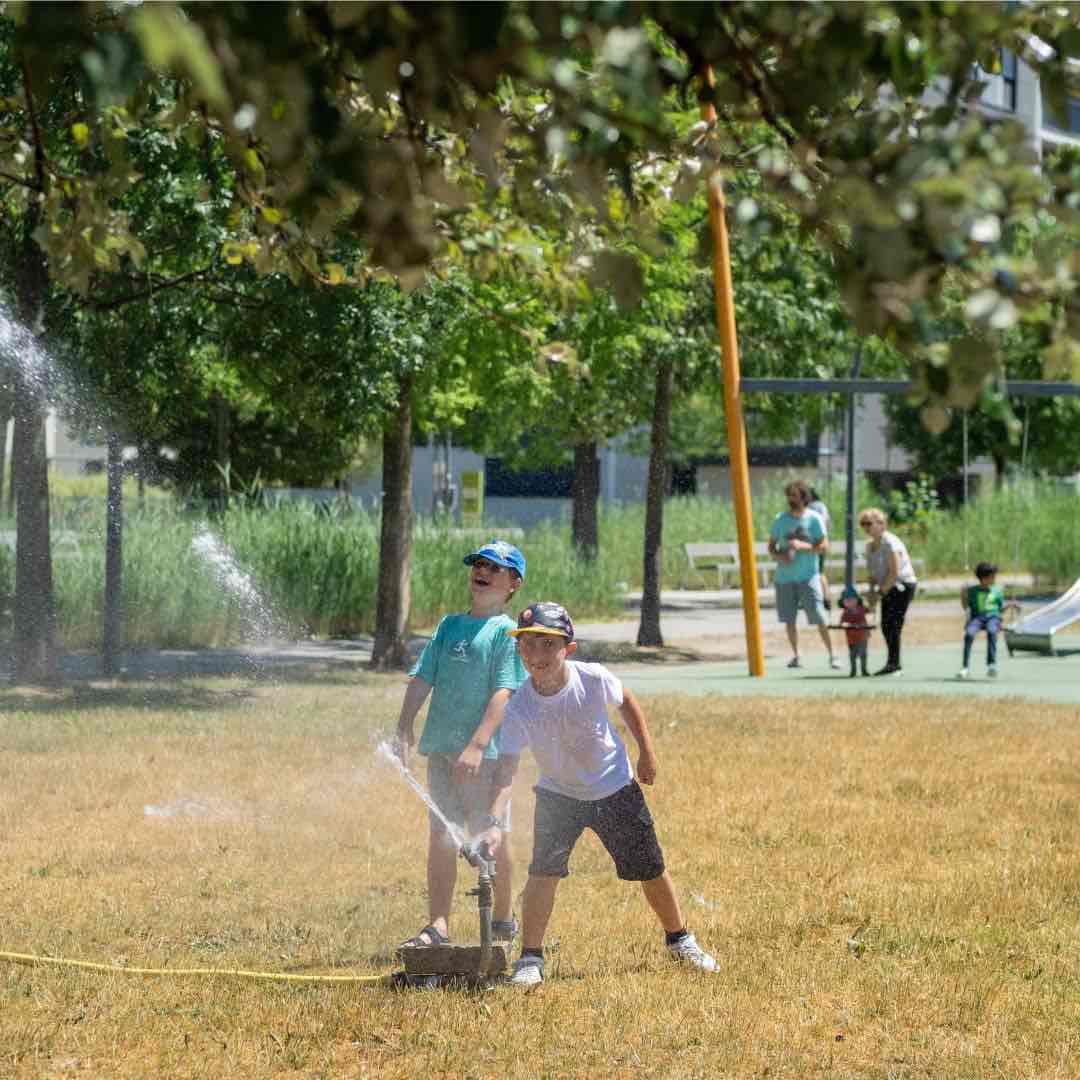 Kinder spielen mit Wasser im Freien während des LEGO Education® Sommer-Camps in Wien