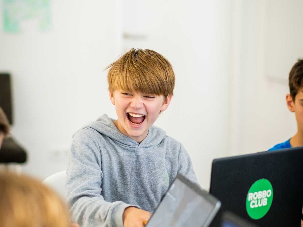 Begeisterter Junge programmiert am Laptop im Robbo Club Wien