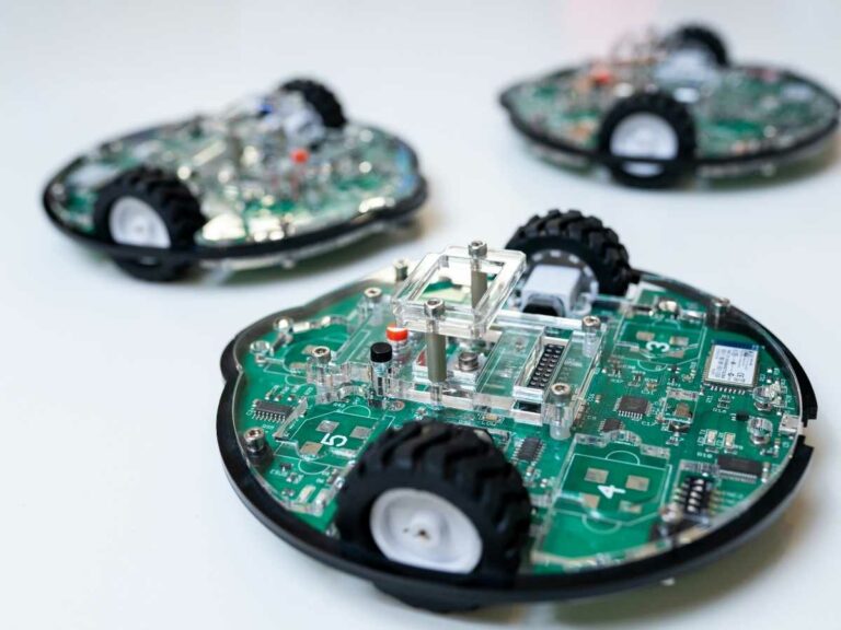 Drei ROBBO Robot Kits: kleine Roboter mit Rädern und offener grüner Platine