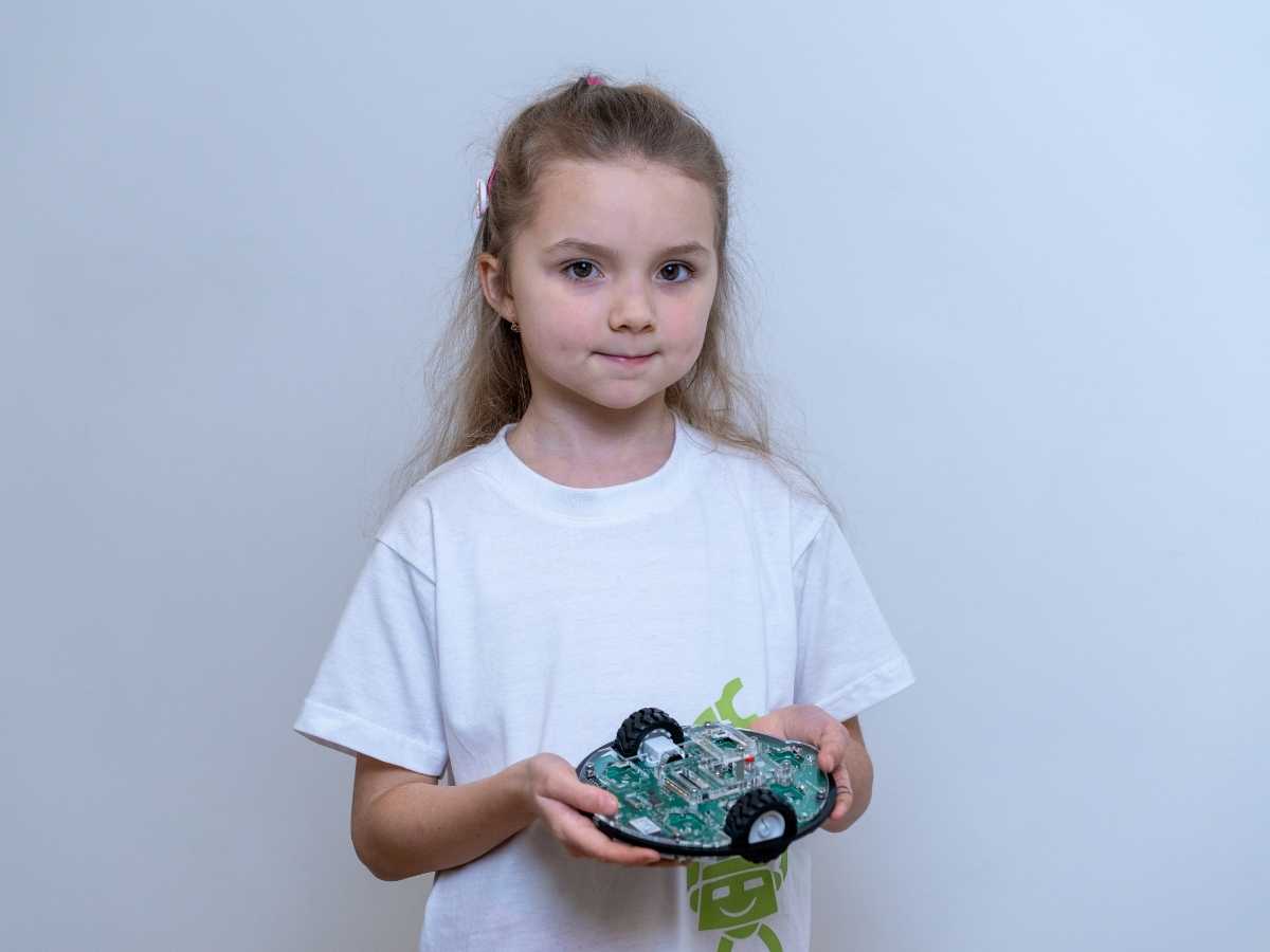 Kind hält selbstgebauten Lernroboter in den Händen bei Robbo Club