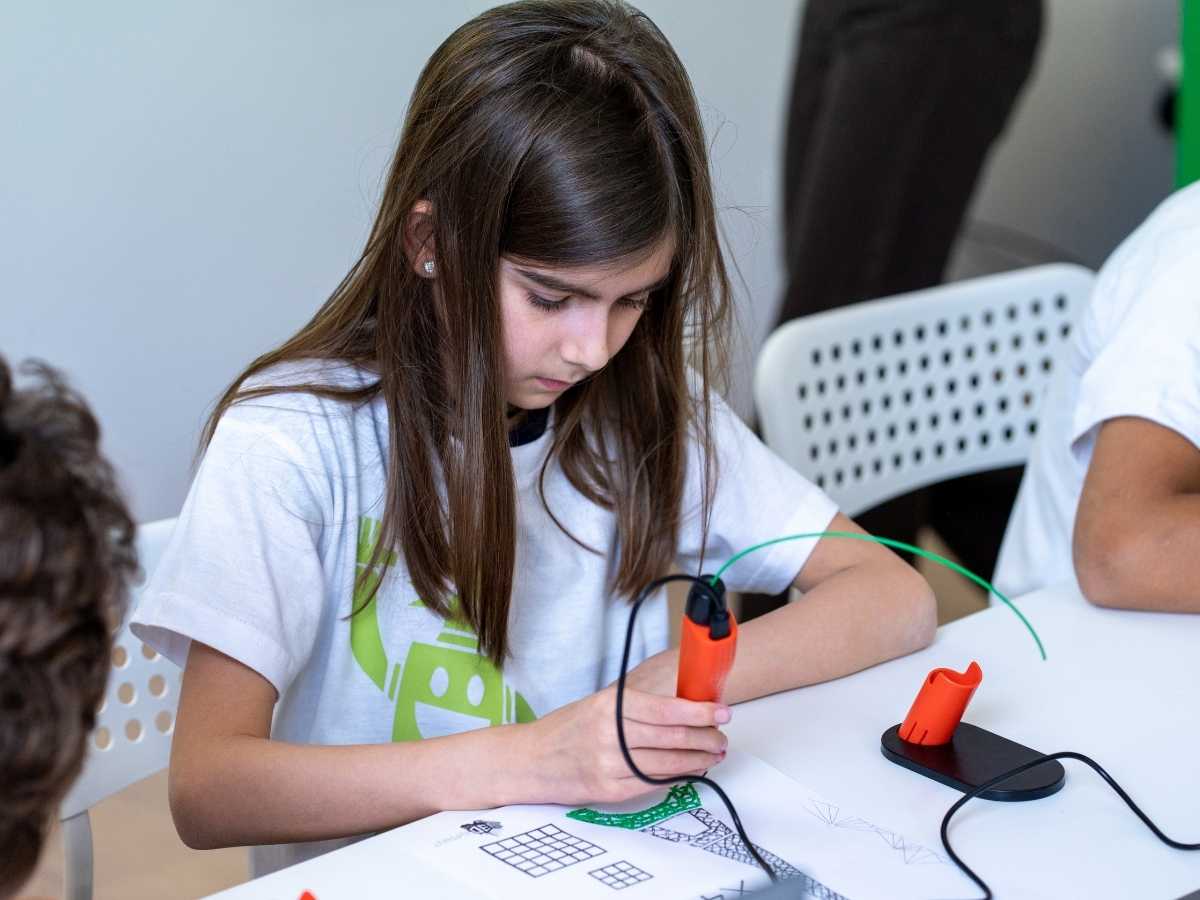 Mädchen arbeitet konzentriert mit Lötkolben im Elektronikunterricht