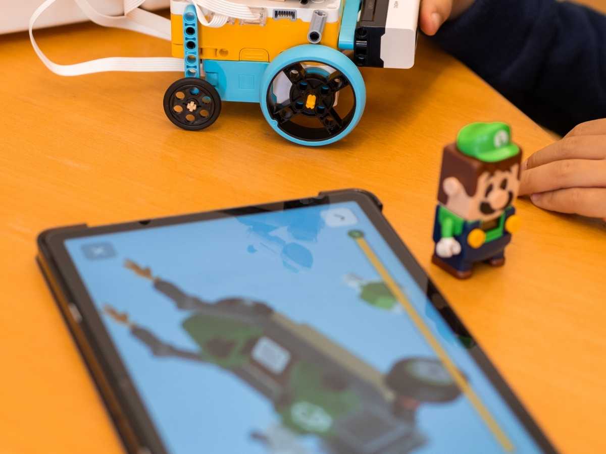 Kind programmiert ein LEGO-Roboterfahrzeug mit Tablet-Unterstützung im Robbo Club.