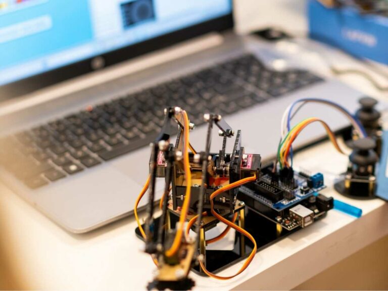 Roboterarm mit Servomotoren, an eine Steuerplatine und einen Laptop angeschlossen
