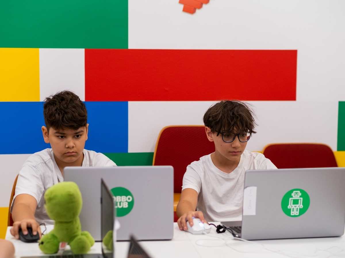 Kinder programmieren gemeinsam am Laptop im Robbo Club