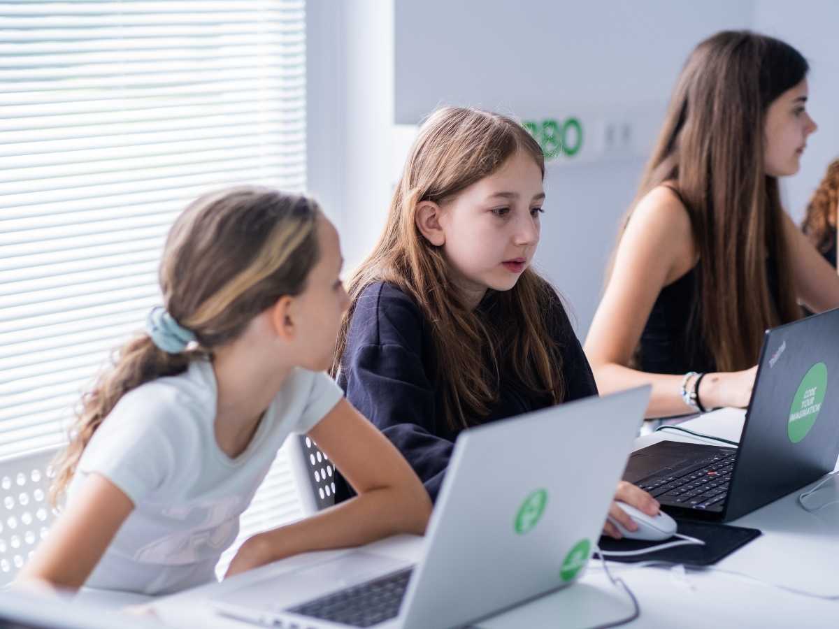 Kinder arbeiten gemeinsam an Laptops im Programmierunterricht bei Robbo Club