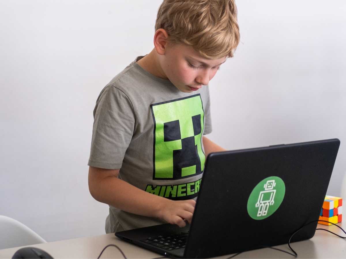 Junge programmiert am Laptop im Robbo Club Unterricht