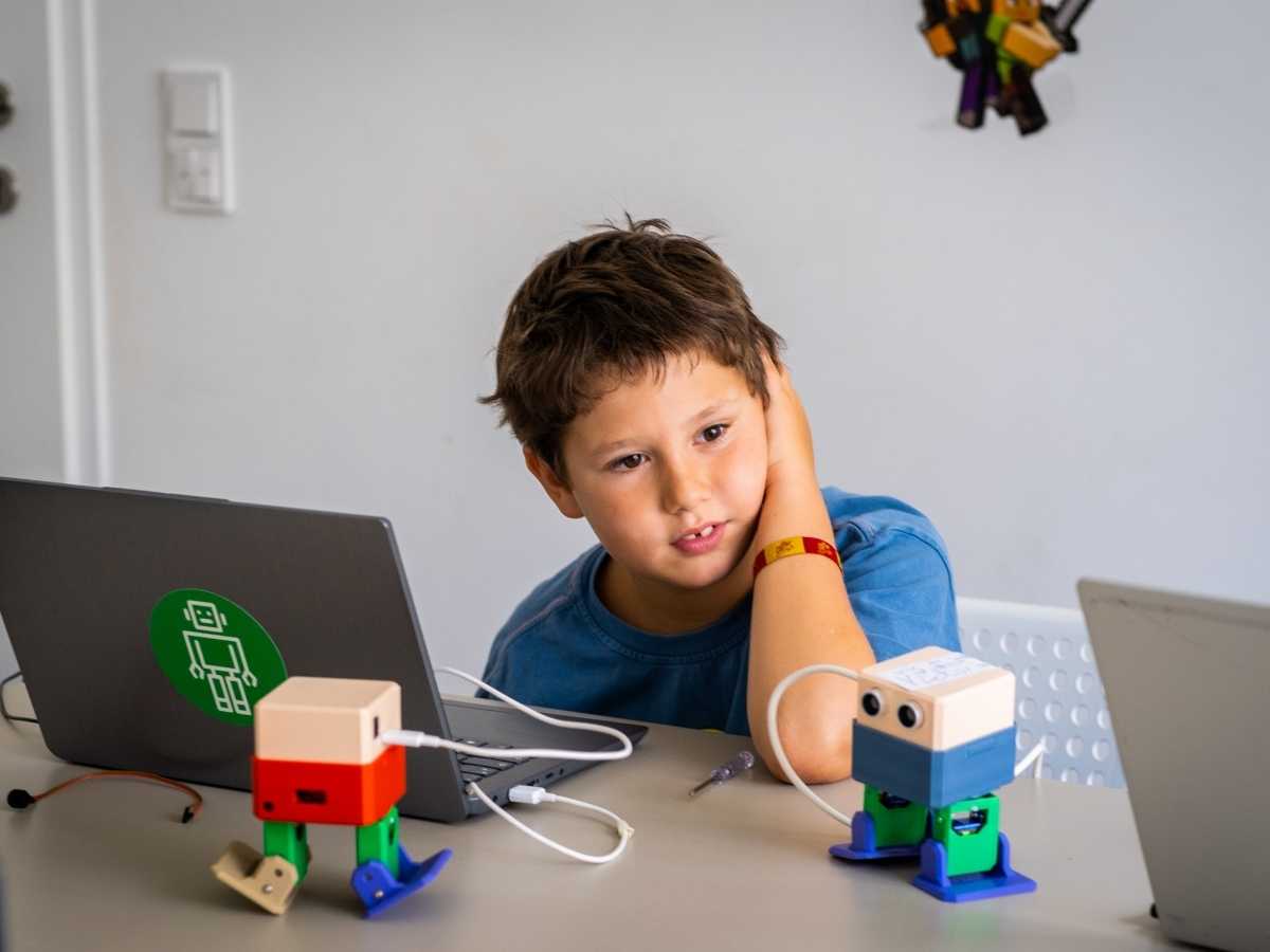 Kind beobachtet programmierte Roboter im Robbo Club