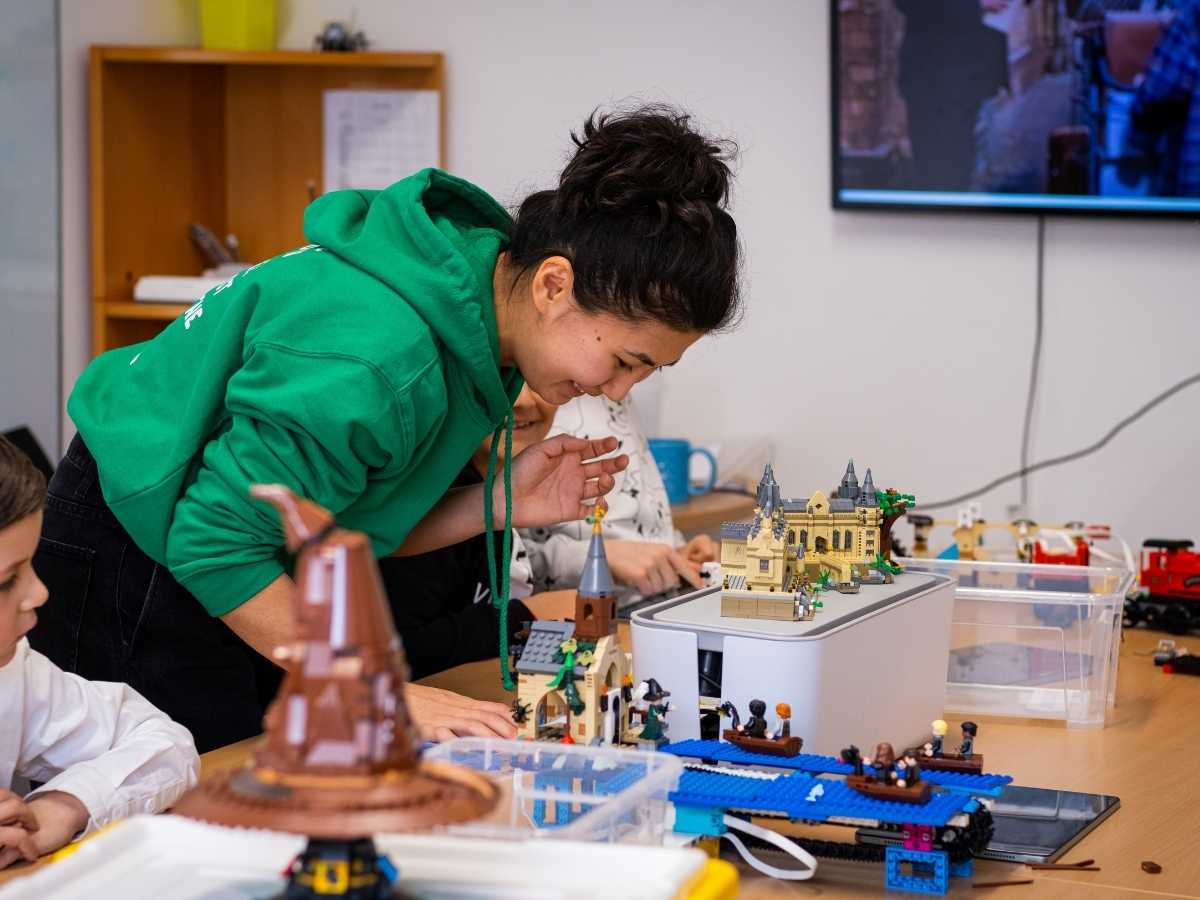 Kinder bauen gemeinsam mit einer Trainerin ein LEGO Technik Modell im Robbo Club.