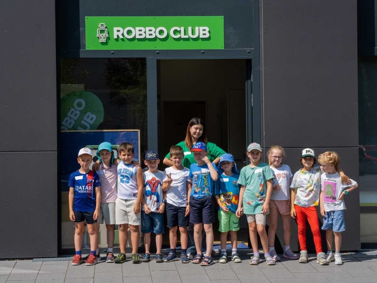 Kindergruppe mit Betreuerin vor dem Robbo Club Eingang