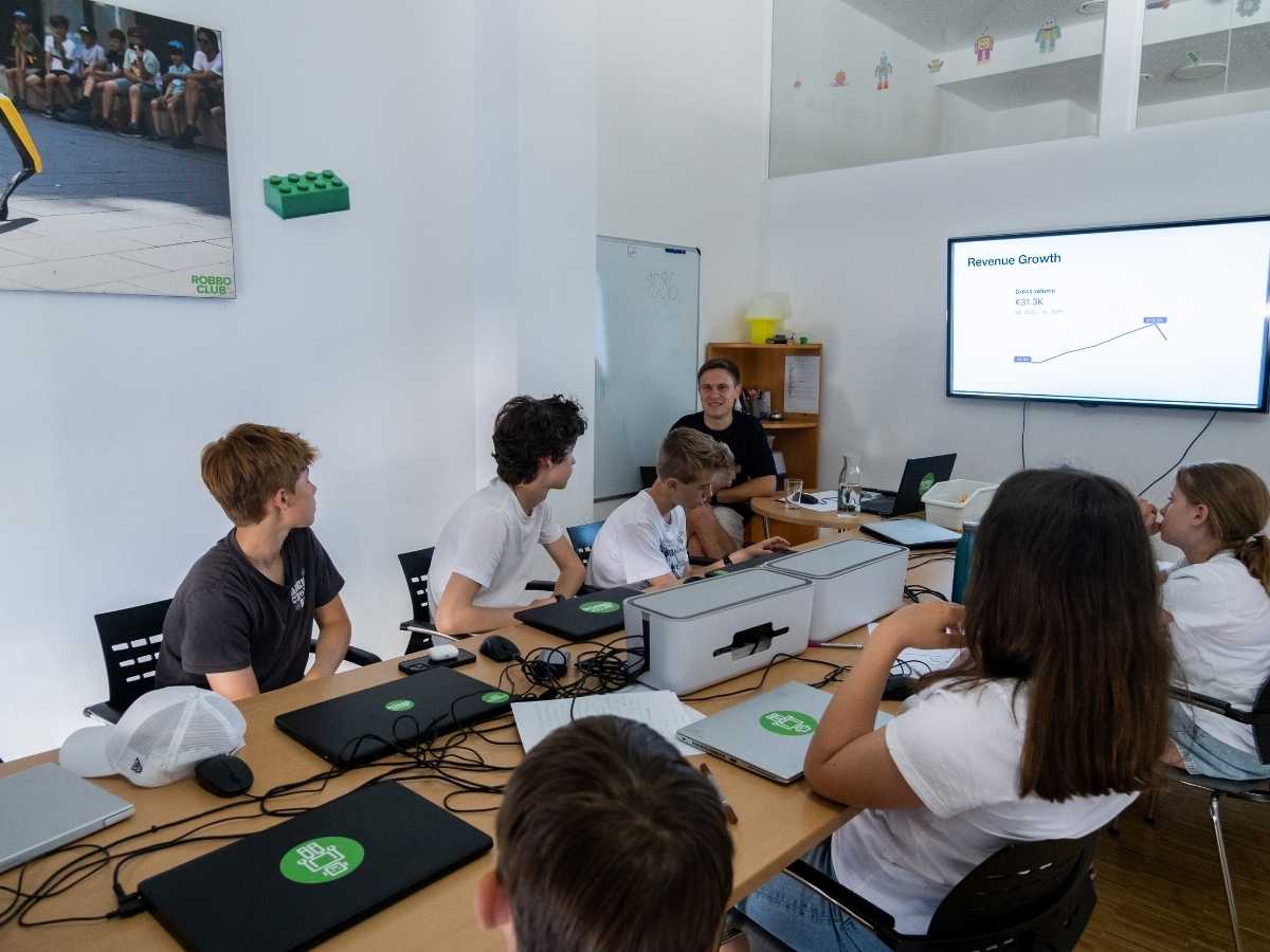 Jugendliche diskutieren ein Projekt mit Laptops im Robbo Club