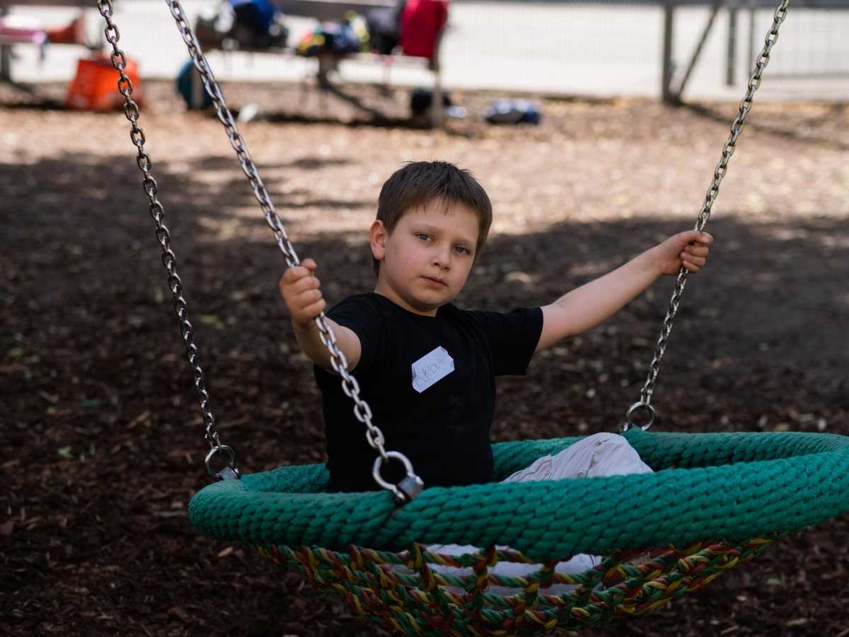 Kind entspannt auf der Schaukel während des Robbo Club Programms