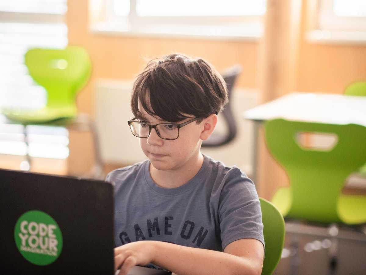 Kind programmiert am Laptop im Robbo Club Unterricht