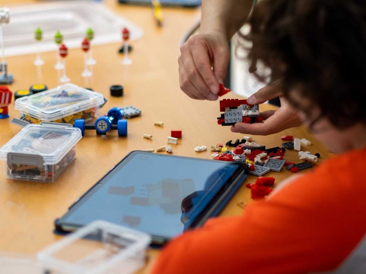 Kind baut LEGO Modell mit Tablet Anleitung
