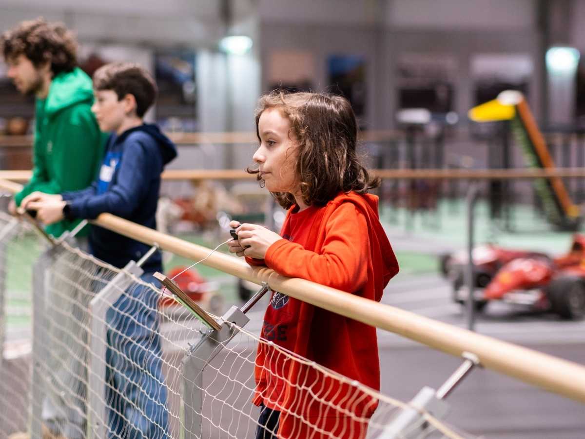 Kind beobachtet ein Autorennen mit ferngesteuerten Fahrzeugen im Robbo Club.