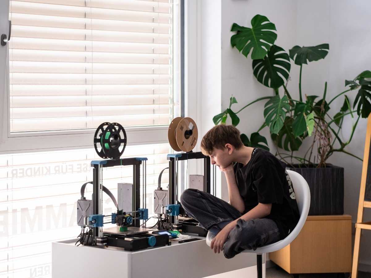 Kind beobachtet einen 3D-Drucker im Technikraum des Robbo Club.
