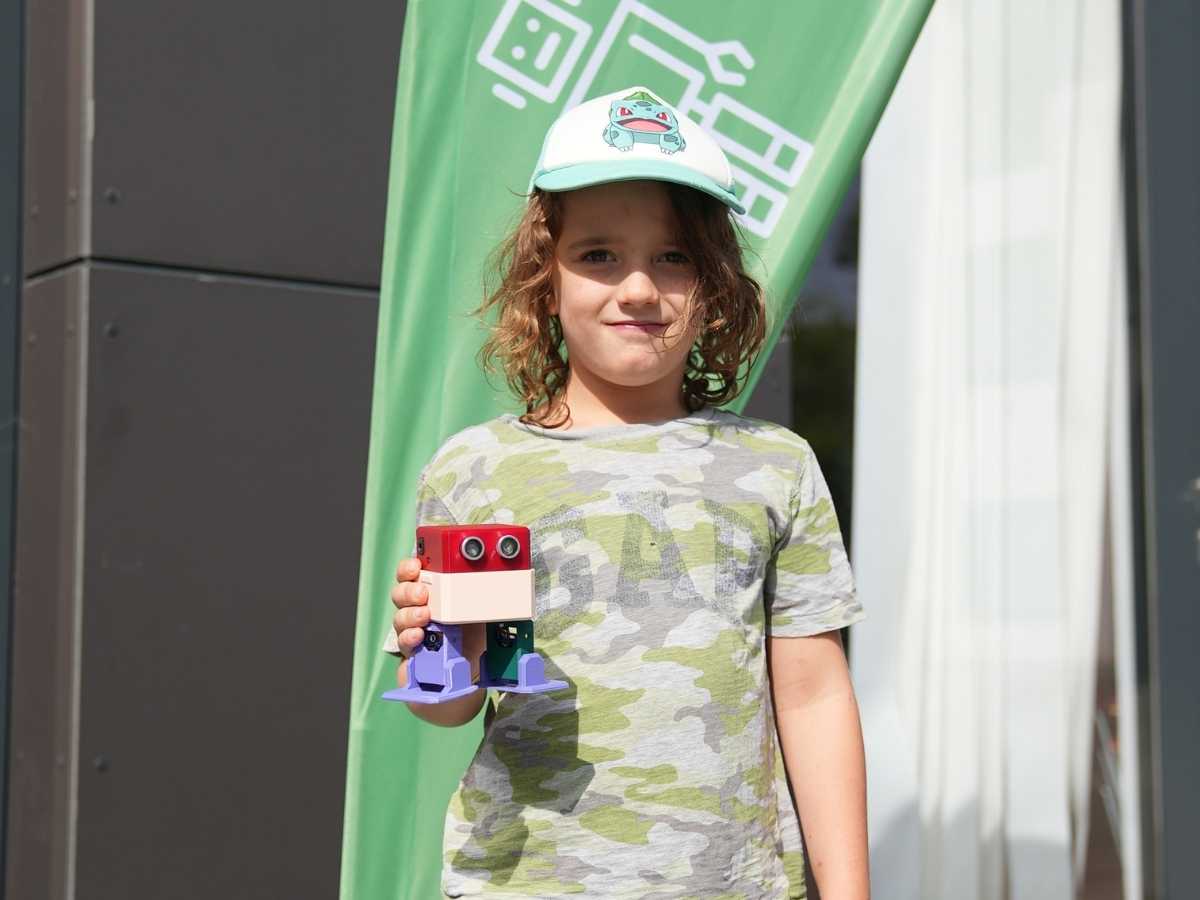 Kind präsentiert selbstgebauten Roboter vor dem Robbo Club