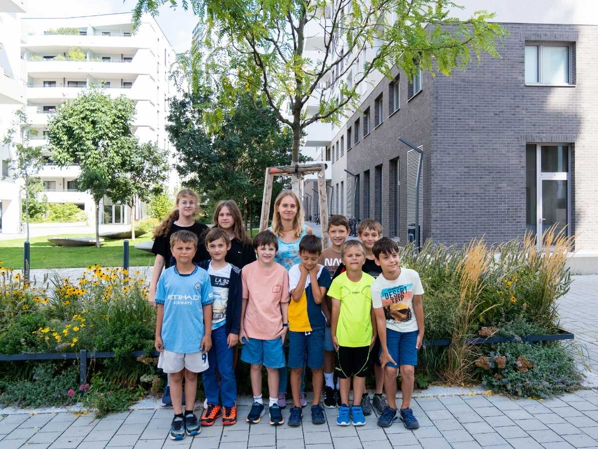 Kindergruppe des Robbo Club in einer grünen Außenanlage in Wien