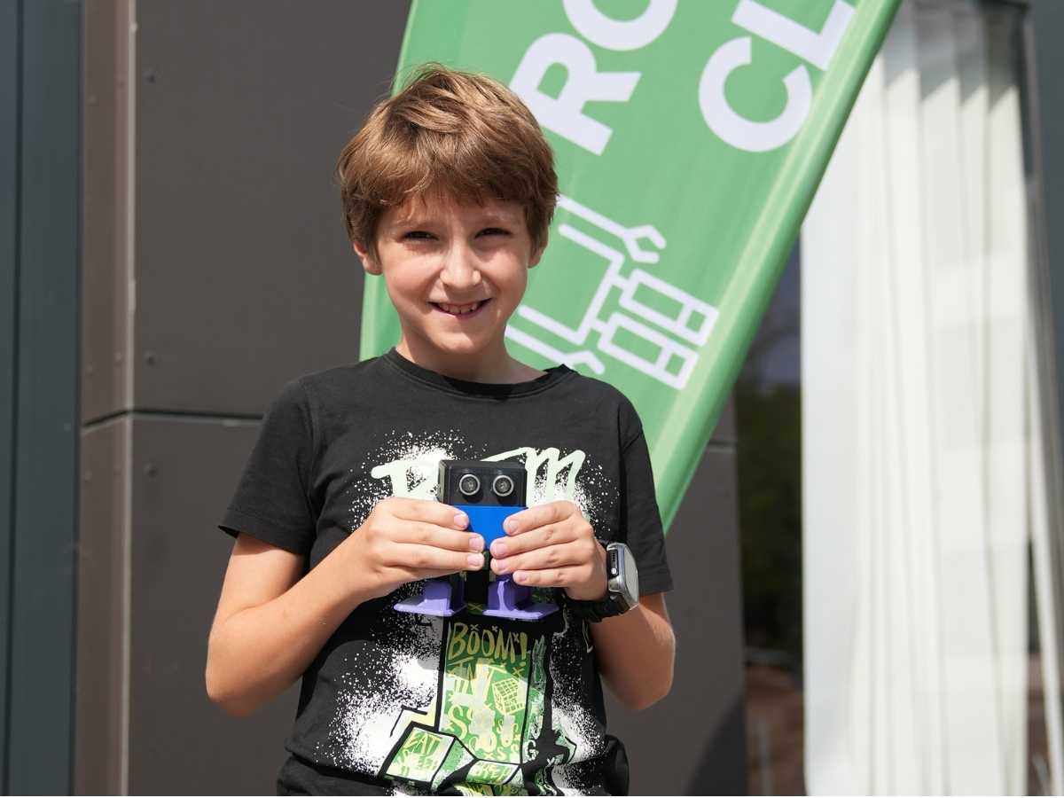 Schüler zeigt seinen Roboter aus dem Robbo Club Kurs