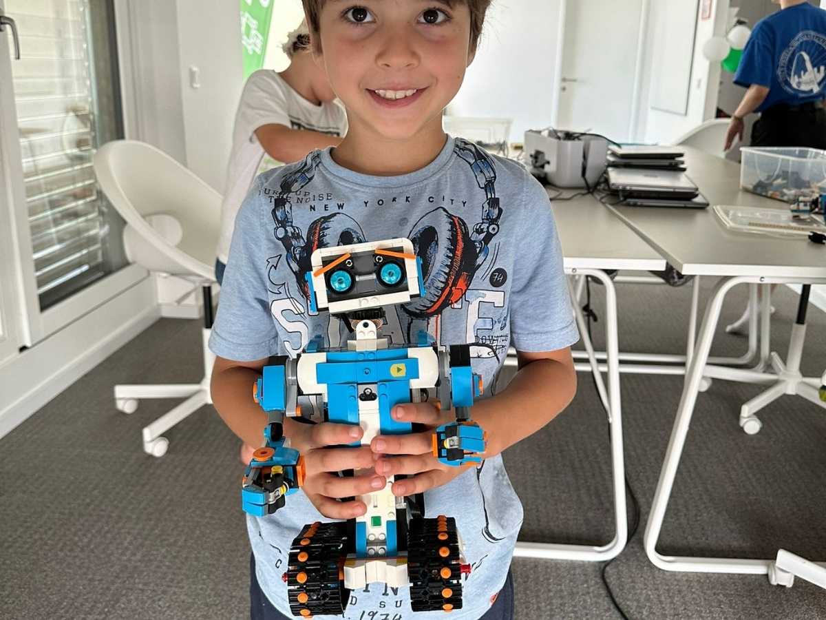 Kind präsentiert selbstgebauten Roboter im Robbo Club Kurs